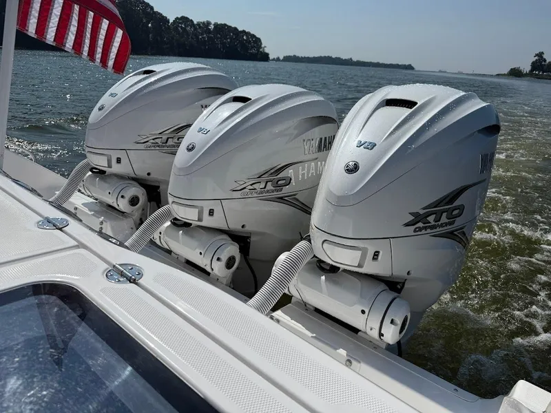 Slide: The Image of Triple Yamaha XTO Offshore engines on 2023 Everglades 395 Center Console boat, cruising on water. - 9