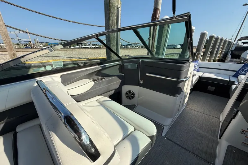 Slide: The Image of 2017 Regal 29 OBX boat interior with white seating and sleek design at a dock. - 8