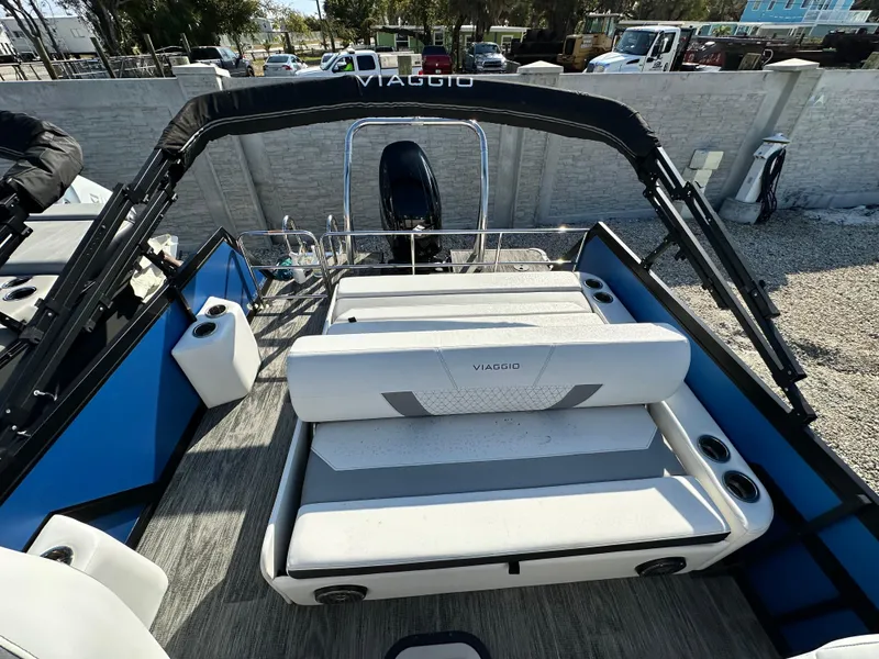 Slide: The Image of 2022 Viaggio Diamante 21S boat interior with seating and canopy, parked outdoors. - 6