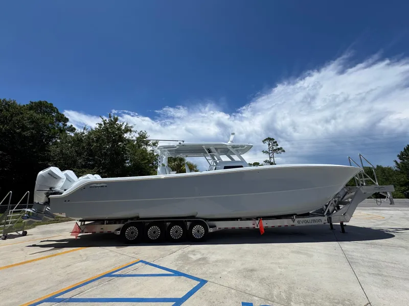 Slide: The Image of 2026 Invincible 46 Catamaran on trailer under clear blue sky. - 10