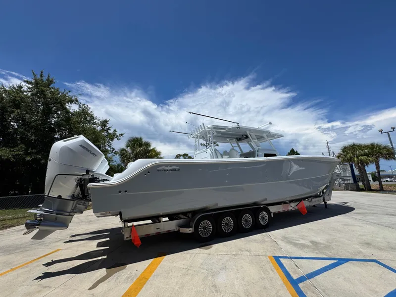 Slide: The Image of 2026 Invincible 46 Catamaran on trailer under clear blue sky. - 11