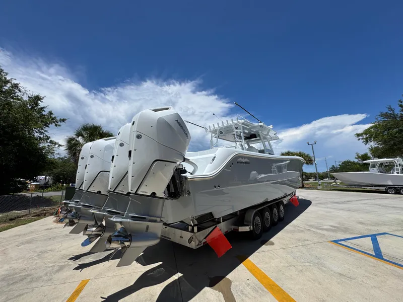 Slide: The Image of 2026 Invincible 46 Catamaran with multiple outboard engines on a trailer, under a clear blue sky. - 12
