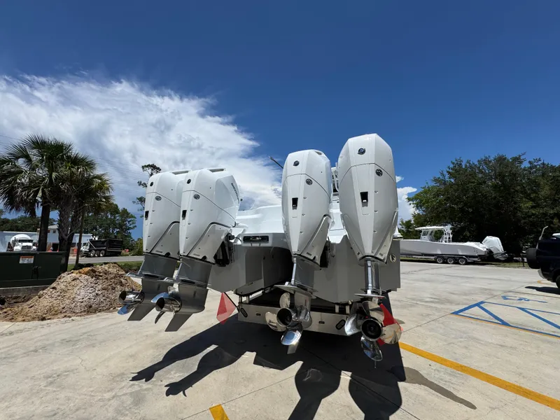 Slide: The Image of 2026 Invincible 46 Catamaran with four powerful outboard engines, parked under a clear blue sky. - 13