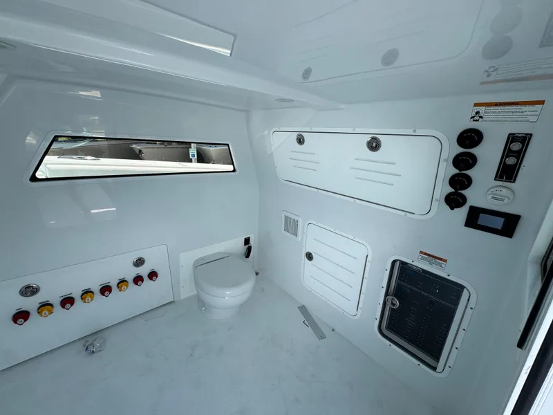 Slide: The Image of Interior of 2026 Invincible 46 Catamaran featuring control panels and a compact toilet. - 25