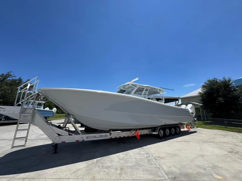 Slide: The Image of 2026 Invincible 46 Catamaran on trailer under clear blue sky. - 3