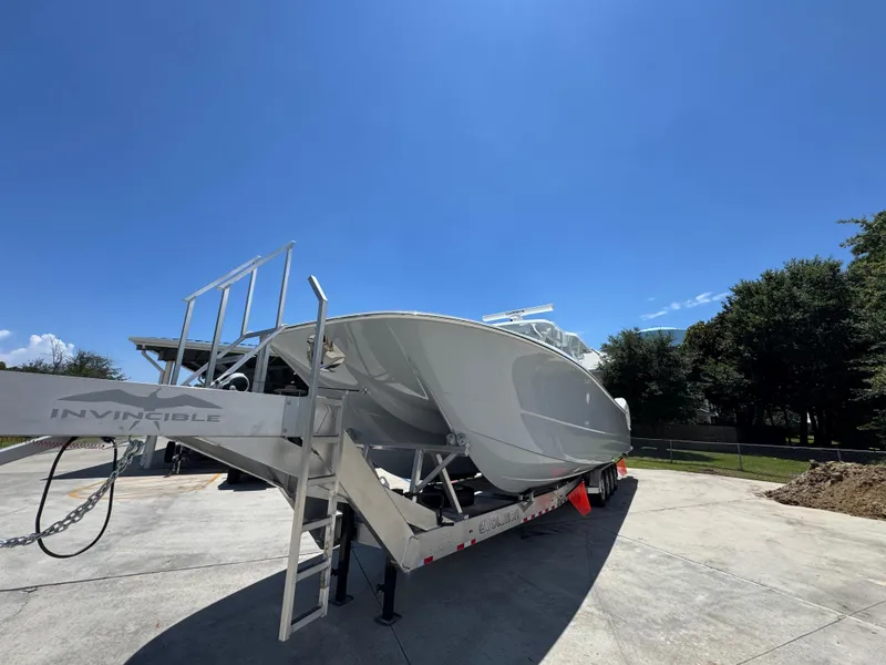 Slide: The Image of 2026 Invincible 46 Catamaran on trailer under clear blue sky. - 5