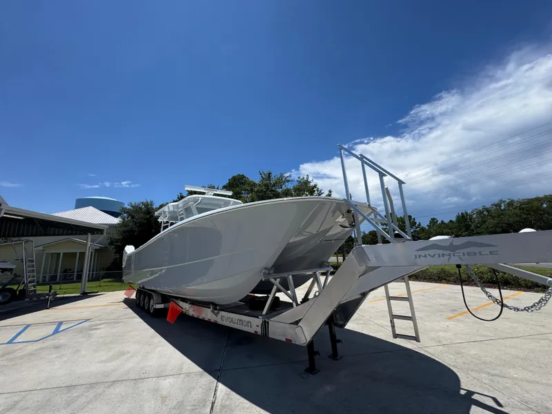 Slide: The Image of 2026 Invincible 46 Catamaran on trailer under clear blue sky. - 8