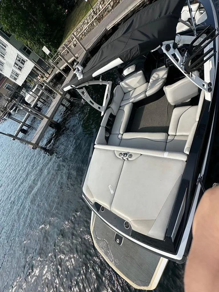 Slide: The Image of 2013 Axis A20 boat with open seating, docked by the water. - 12