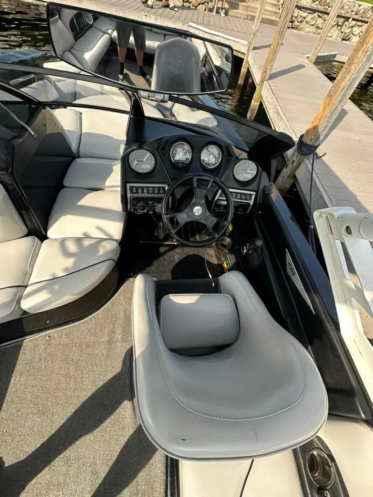 Slide: The Image of 2013 Axis A20 boat interior with steering wheel, gauges, and seating. - 13