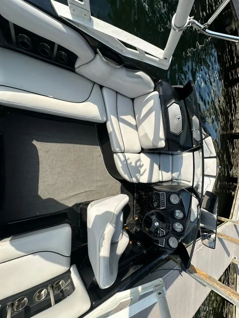 Slide: The Image of Interior of a 2013 Axis A20 boat with white seating and control panel. - 14