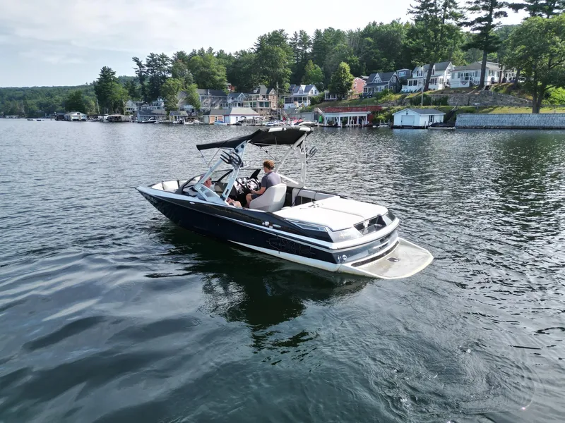 Slide: The Image of 2013 Axis A20 boat on a scenic lake with waterfront homes in the background. - 5