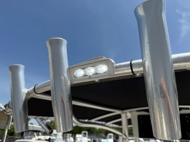 Slide: The Image of 2019 Sea Born LX21 Center Console boat with rod holders and LED lights under a clear sky. - 22