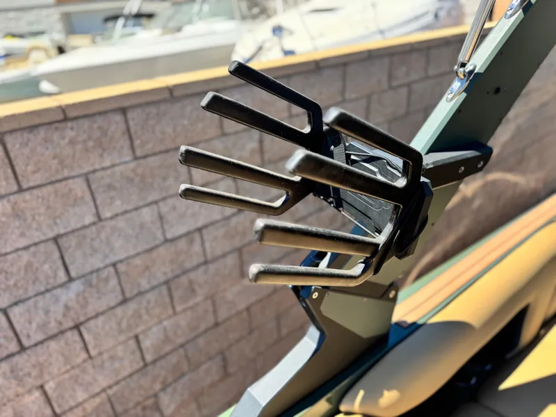 Slide: The Image of 2022 MB F21 Tomcat boat with a wakeboard rack, docked near a brick wall. - 10