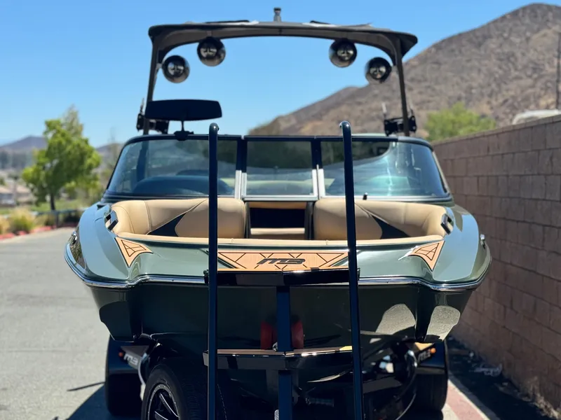 Slide: The Image of 2022 MB F21 Tomcat boat on trailer, parked outdoors with mountains in background. - 2