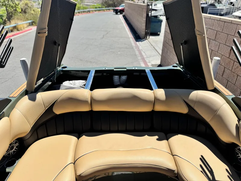 Slide: The Image of 2022 MB F21 Tomcat boat interior with tan leather seating and open storage compartments. - 24