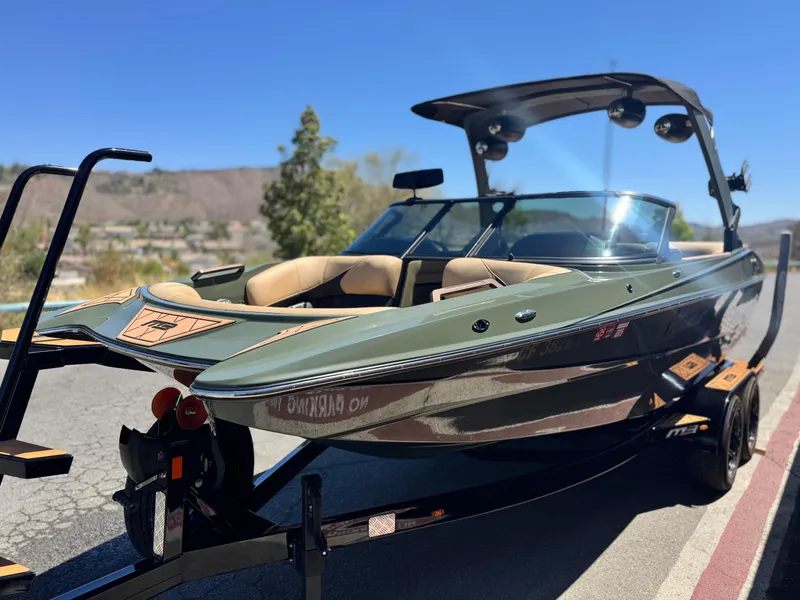 Slide: The Image of 2022 MB F21 Tomcat boat on trailer, parked outdoors under clear blue sky. - 3