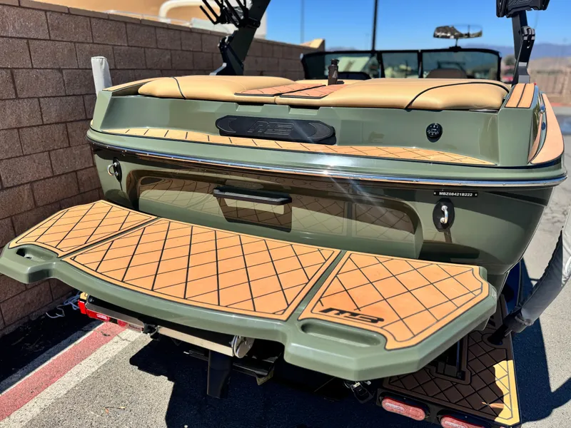 Slide: The Image of 2022 MB F21 Tomcat boat with tan deck, parked near a brick wall. - 6