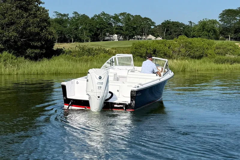 Slide: The Image of 2026 Rossiter 23 OPEN boat cruising on a calm river with lush greenery. - 12
