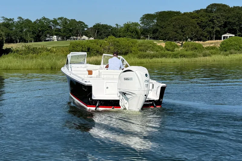 Slide: The Image of 2026 Rossiter 23 OPEN boat cruising on a serene lake with lush greenery. - 14