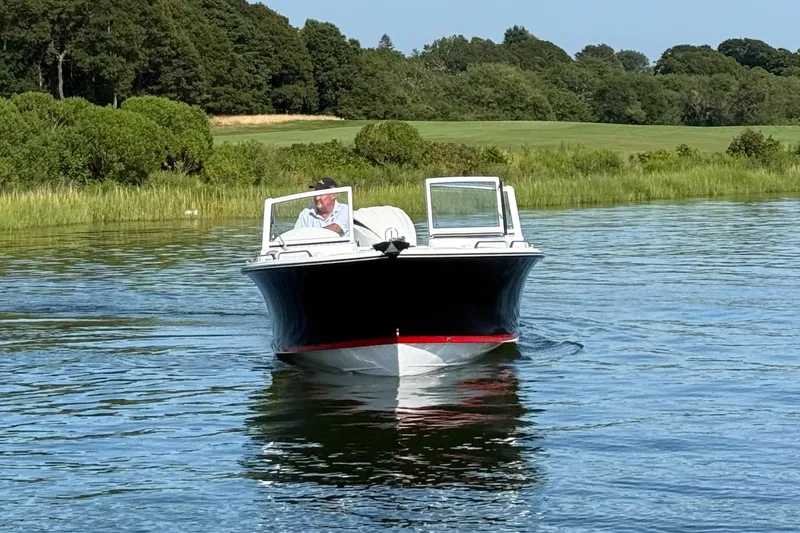 Slide: The Image of 2026 Rossiter 23 OPEN boat cruising on a serene lake with lush greenery. - 5
