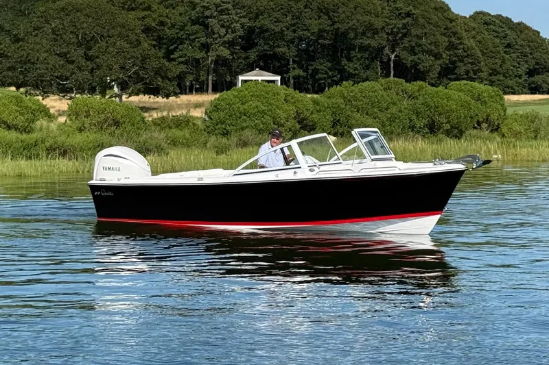 Slide: The Image of 2026 Rossiter 23 OPEN boat on calm water with lush green background. - 7