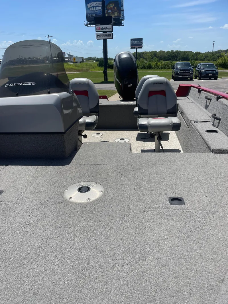 Slide: The Image of 2012 Tracker Pro Guide 175 boat interior with seating and motor, parked outdoors. - 7