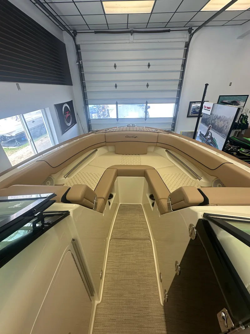 Slide: The Image of 2024 Chris-Craft Launch 25 GT boat interior with tan seating in showroom. - 11