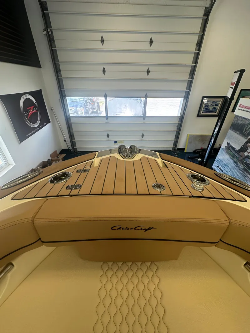 Slide: The Image of 2024 Chris-Craft Launch 25 GT boat interior with teak deck in a showroom. - 12