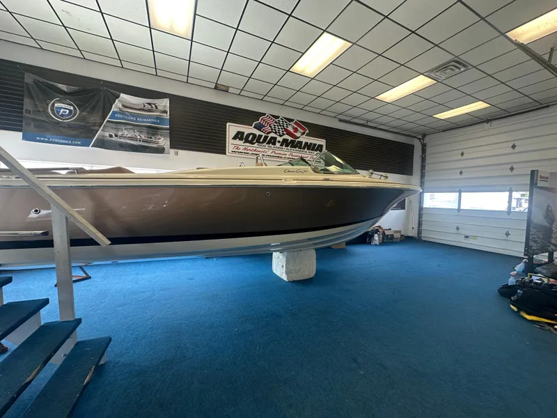 Slide: The Image of 2024 Chris-Craft Launch 25 GT boat displayed indoors on blue carpet. - 2