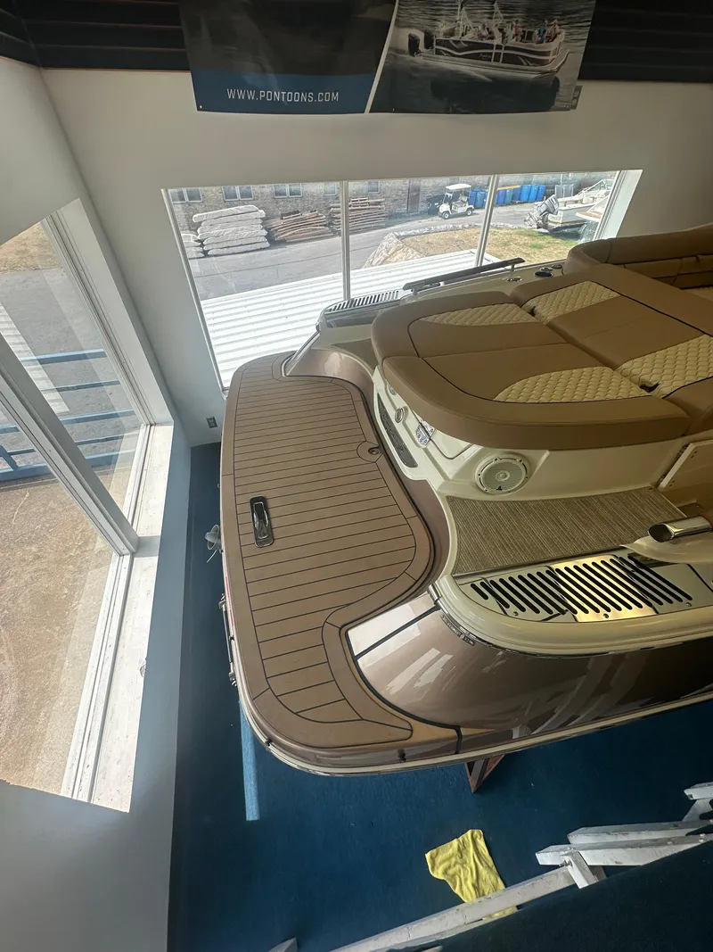Slide: The Image of 2024 Chris-Craft Launch 25 GT boat displayed indoors, showcasing elegant deck design. - 21