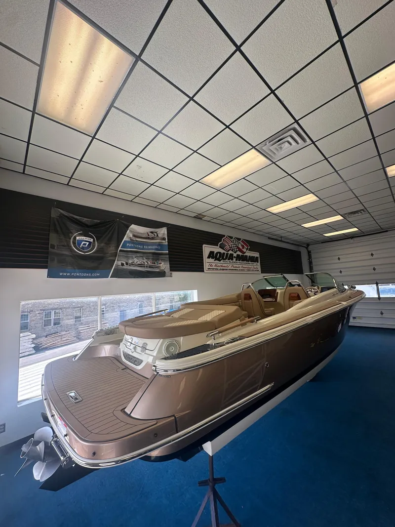 Slide: The Image of 2024 Chris-Craft Launch 25 GT boat displayed indoors on a blue carpet. - 27