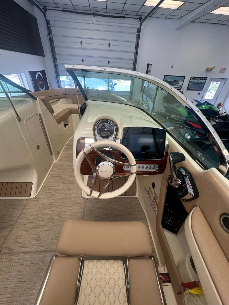 Slide: The Image of 2024 Chris-Craft Launch 25 GT interior with steering wheel and dashboard in showroom. - 9