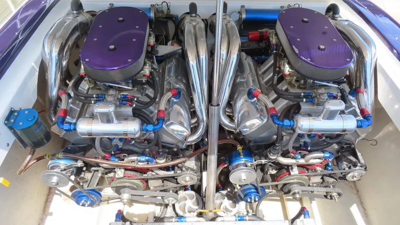 Slide: The Image of Twin engines of a 1998 Hustler 388 SLINGSHOT with chrome components and purple accents. - 17