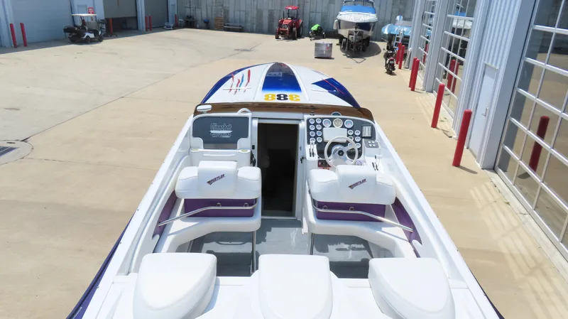 Slide: The Image of 1998 Hustler 388 SLINGSHOT speedboat with dual seats and control panel in a marina setting. - 5