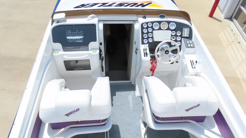 Slide: The Image of 1998 Hustler 388 SLINGSHOT boat interior with white seats and detailed dashboard controls. - 6