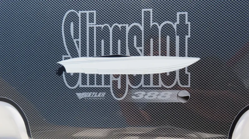 Slide: The Image of 1998 Hustler 388 Slingshot logo on carbon fiber background. - 9