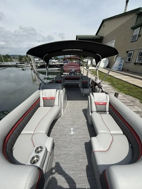 Slide: The Image of 2024 Bennington 24 LXSSB pontoon boat with luxurious seating and canopy at a dock. - 11
