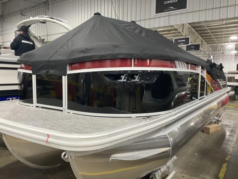 Slide: The Image of 2024 Bennington 24 LXSSB pontoon boat with black cover in a showroom. - 18
