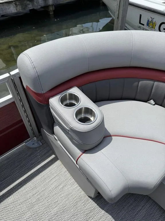 Slide: The Image of 2024 Bennington 24 LXSSB boat seat with cup holders, featuring gray and red upholstery. - 19