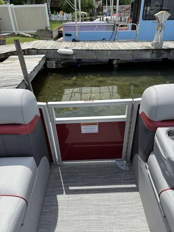 Slide: The Image of 2024 Bennington 24 LXSSB pontoon boat interior with dock view. - 22