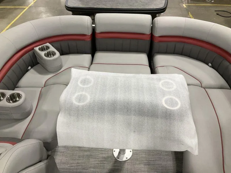 Slide: The Image of 2024 Bennington 24 LXSSB boat interior with gray and red seating, cup holders, and a covered table. - 23