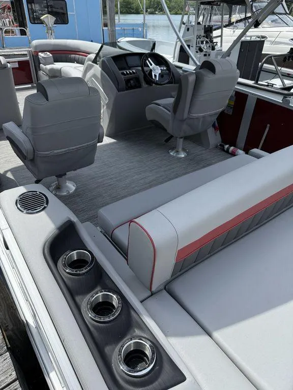 Slide: The Image of 2024 Bennington 24 LXSSB boat interior with gray seating and steering console. - 6