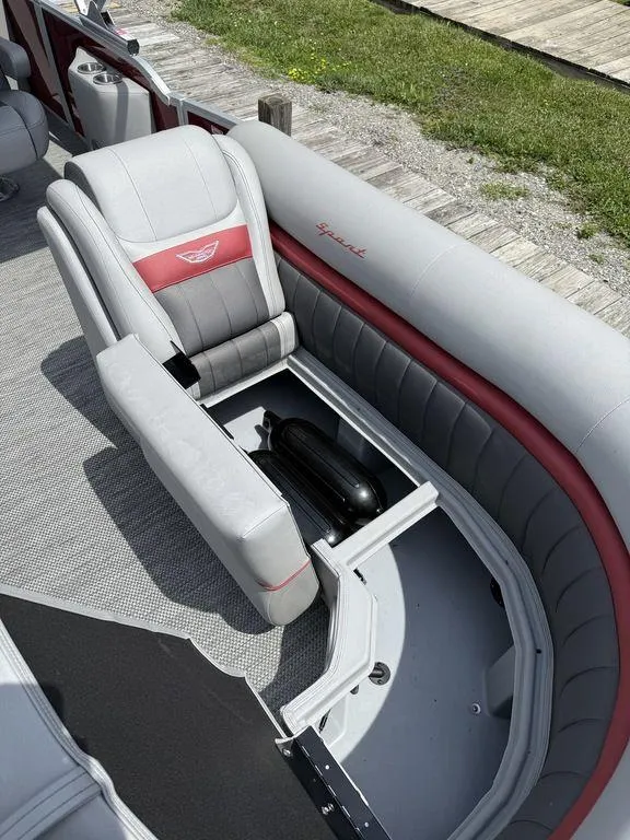 Slide: The Image of 2024 Bennington 24 LXSSB boat interior with open storage compartment and cushioned seating. - 9