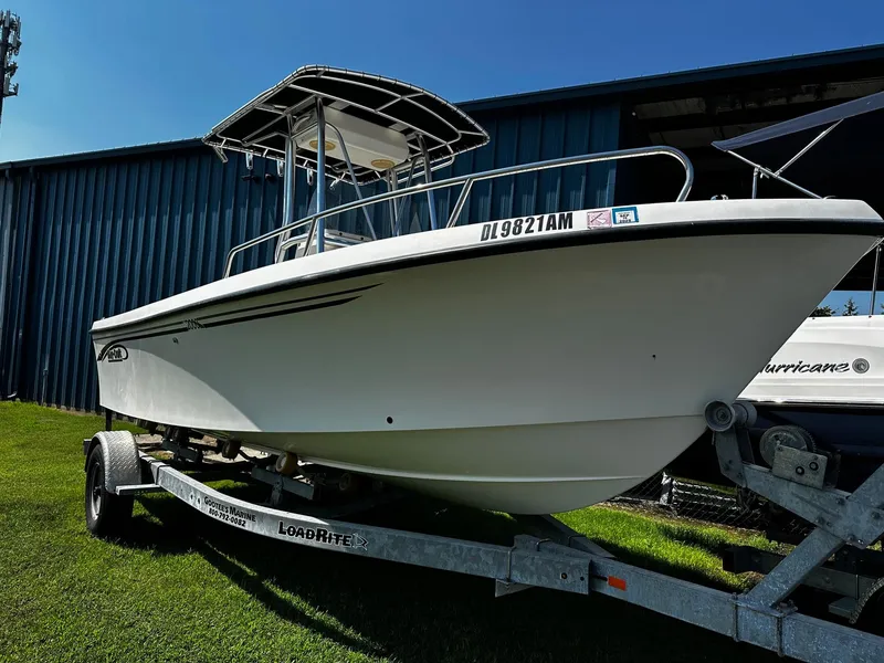 Slide: The Image of 2011 May-Craft 2000CC boat on trailer, parked on grass near blue building. - 1