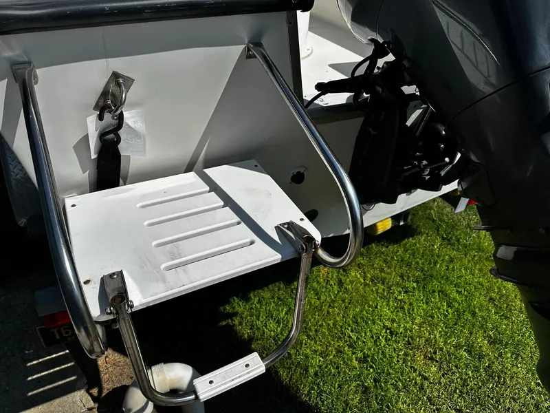 Slide: The Image of 2011 May-Craft 2000CC boat ladder and motor detail on grass. - 14
