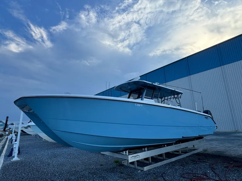 The Image of 2022 Invincible 40 Catamaran in blue, docked outdoors under a cloudy sky. - 1