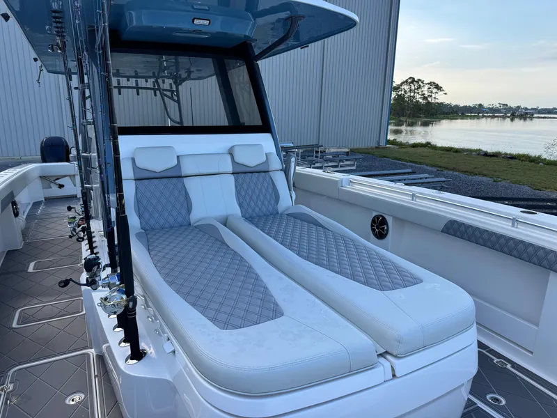 Slide: The Image of 2022 Invincible 40 Catamaran with luxurious seating, docked by a serene waterfront. - 13