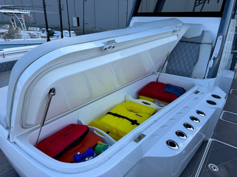 Slide: The Image of Open storage compartment on 2022 Invincible 40 Catamaran with safety gear and emergency kit. - 14