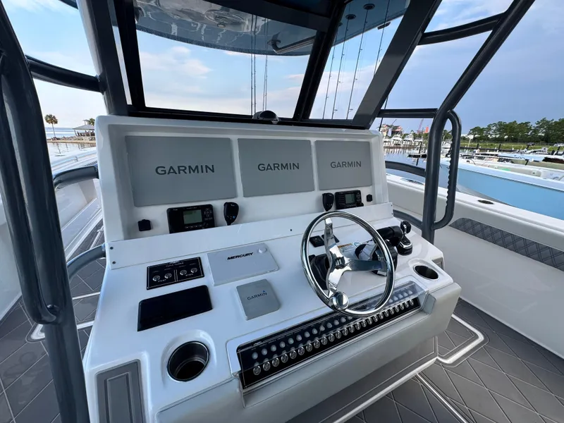 Slide: The Image of Helm of 2022 Invincible 40 Catamaran featuring Garmin displays and Mercury controls. - 18