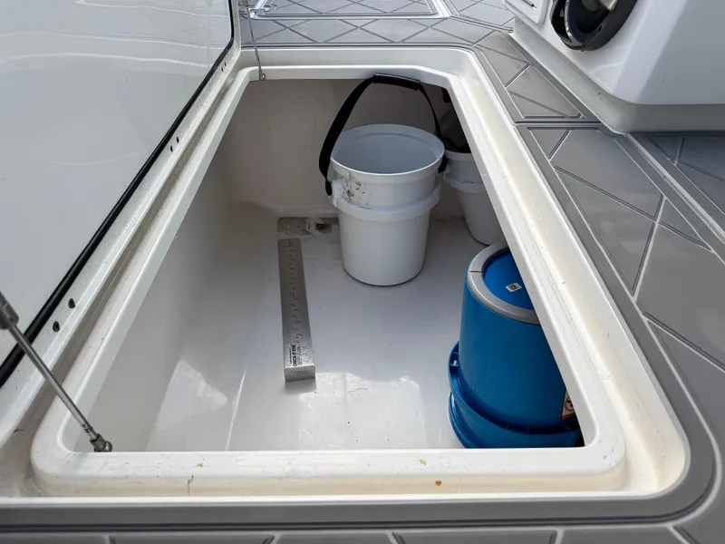 Slide: The Image of Storage compartment on 2022 Invincible 40 Catamaran with buckets and a ruler. - 27